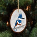 A hand-painted bird on a wood slice that is hanging on a Christmas tree at Cove Creek Photography.